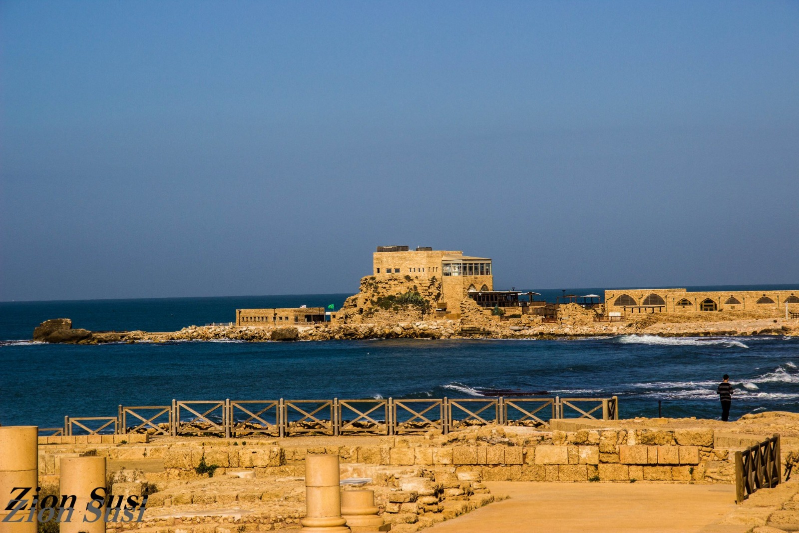 Ancient stone ruins and harbor of Caesarea Maritima along the blue Mediterranean coastline