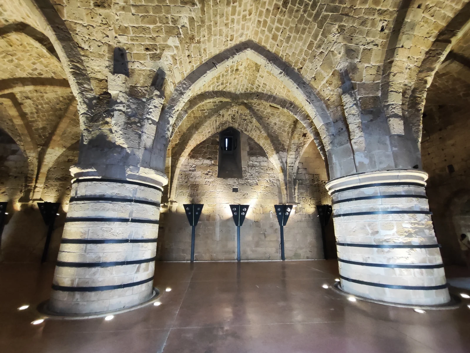 Interior of the Crusader Knights' Halls in Acre with massive reinforced stone columns and a grand vaulted ceiling