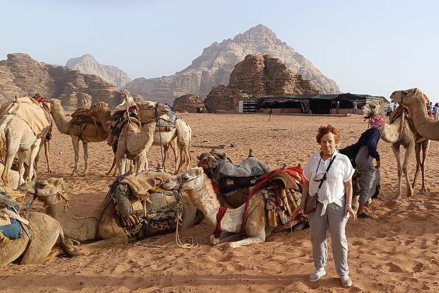 Camels and travelers at a Bedouin camp beneath the Wadi Rum mountains