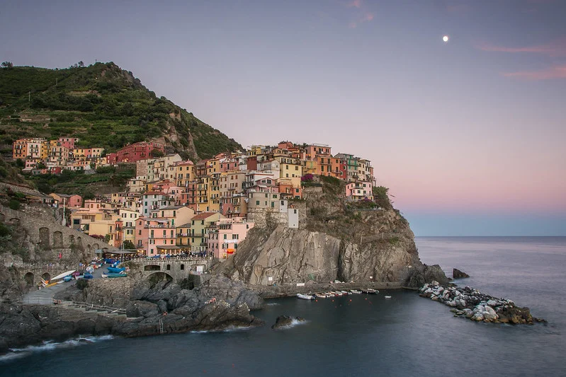 Manarola perched on the cliffs at sunset with the moon above