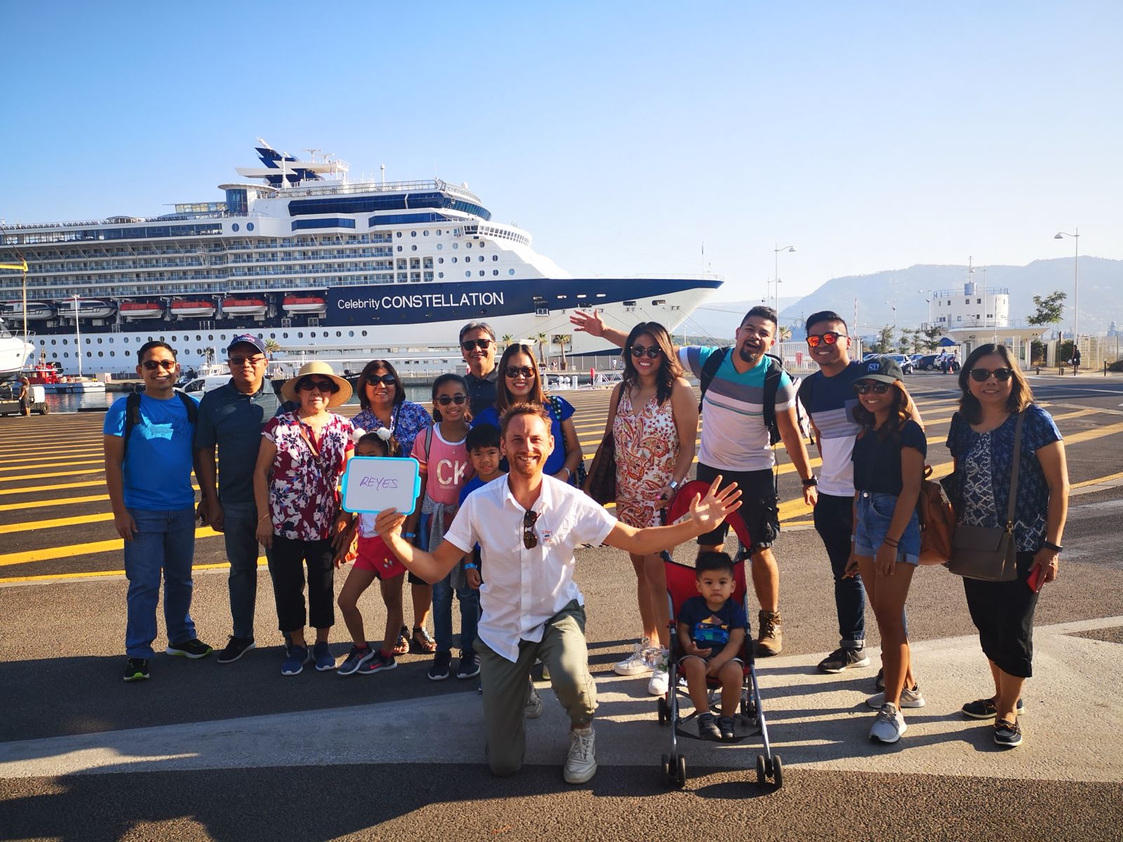 Happy tour group with their guide in front of a cruise ship