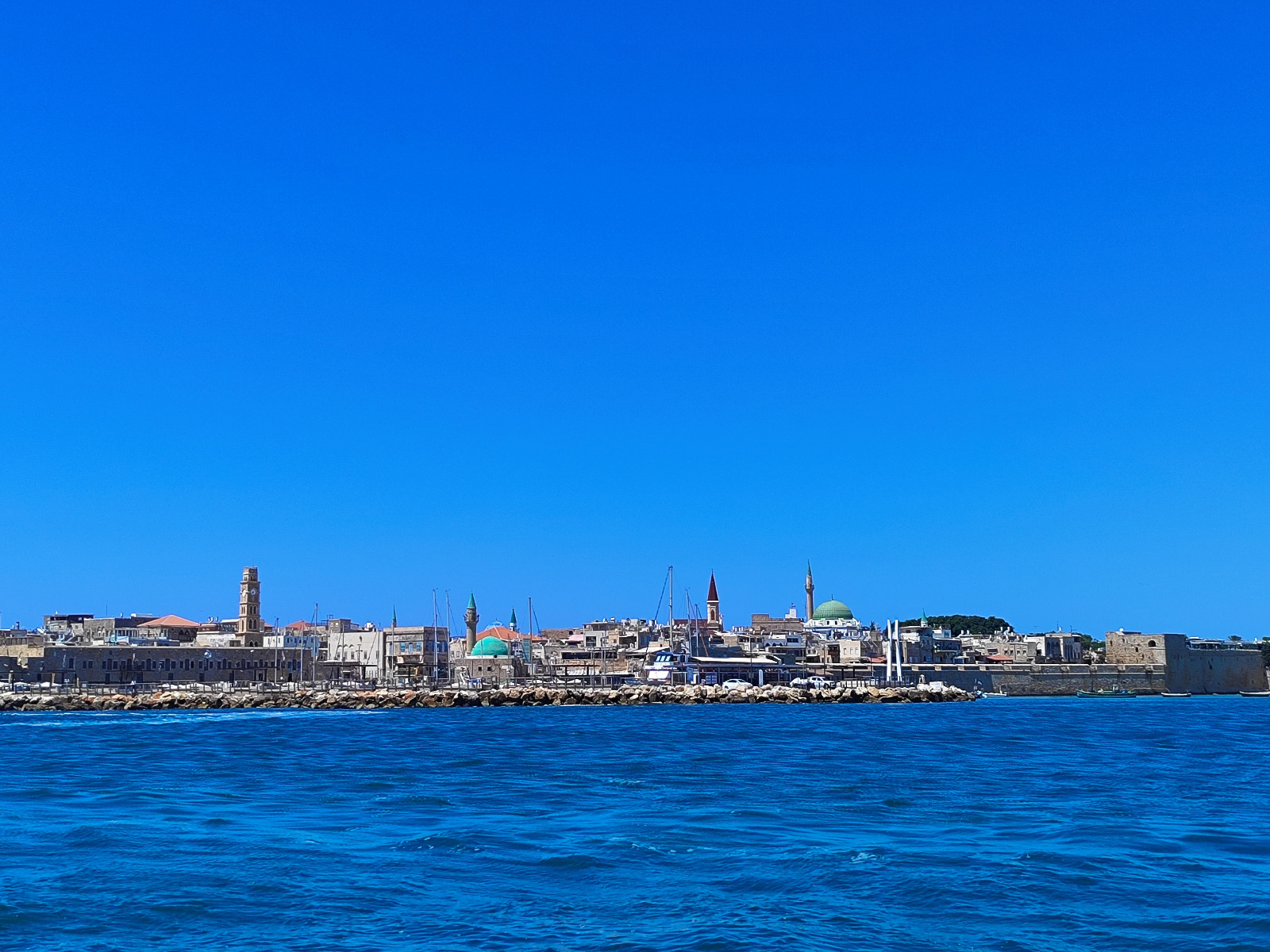 Old Acre skyline seen from the Mediterranean sea with the Al-Jazzar Mosque green dome and clock tower