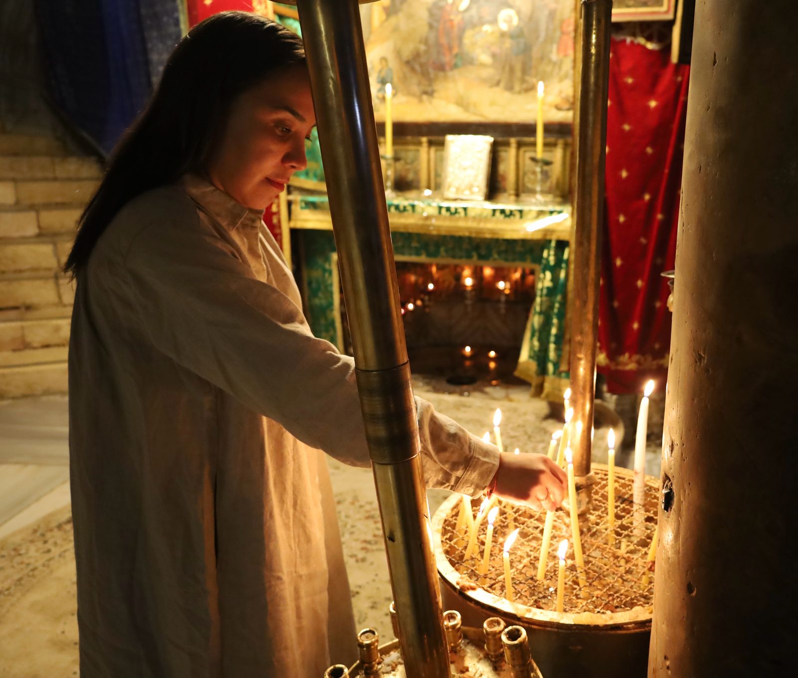 Guest lighting a candle at the Grotto of the Nativity in Bethlehem