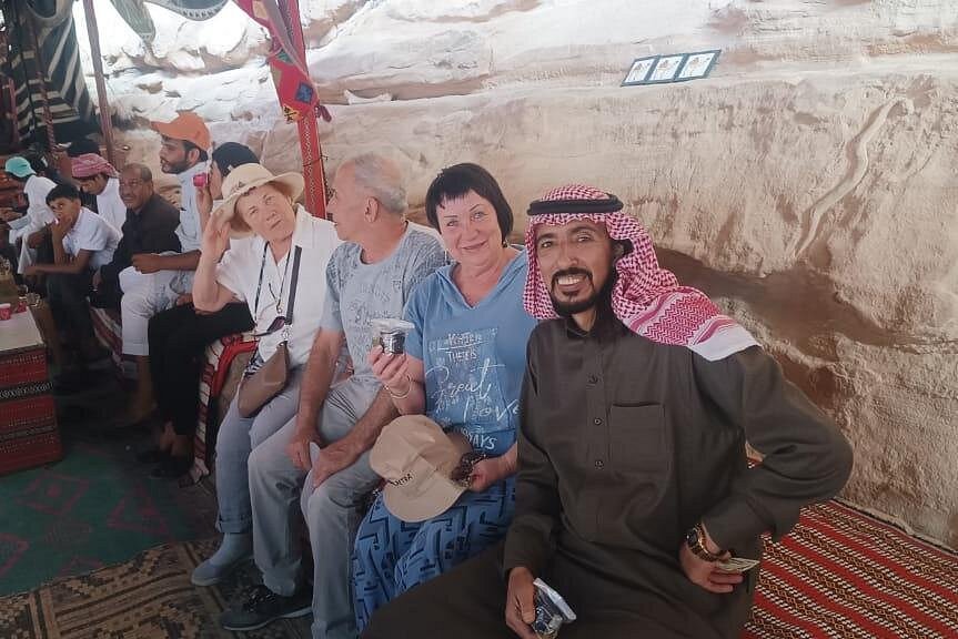 Private tour guests sharing Bedouin hospitality in a shaded desert tent