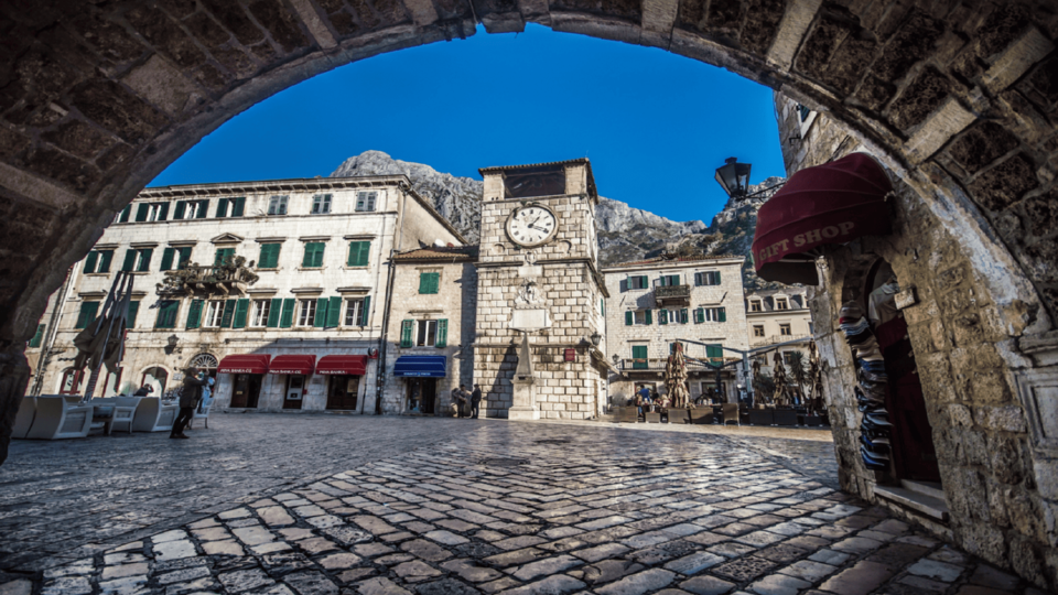 Kotor Old Town clock tower framed by a stone archway