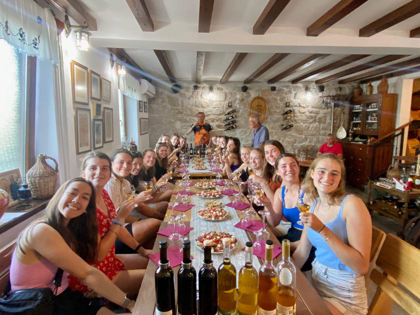 Guests enjoying a wine tasting in a rustic stone family-run winery