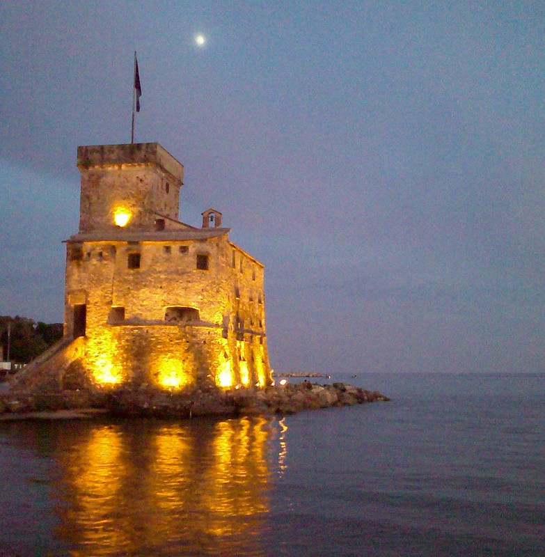 Rapallo castle illuminated at night by the sea