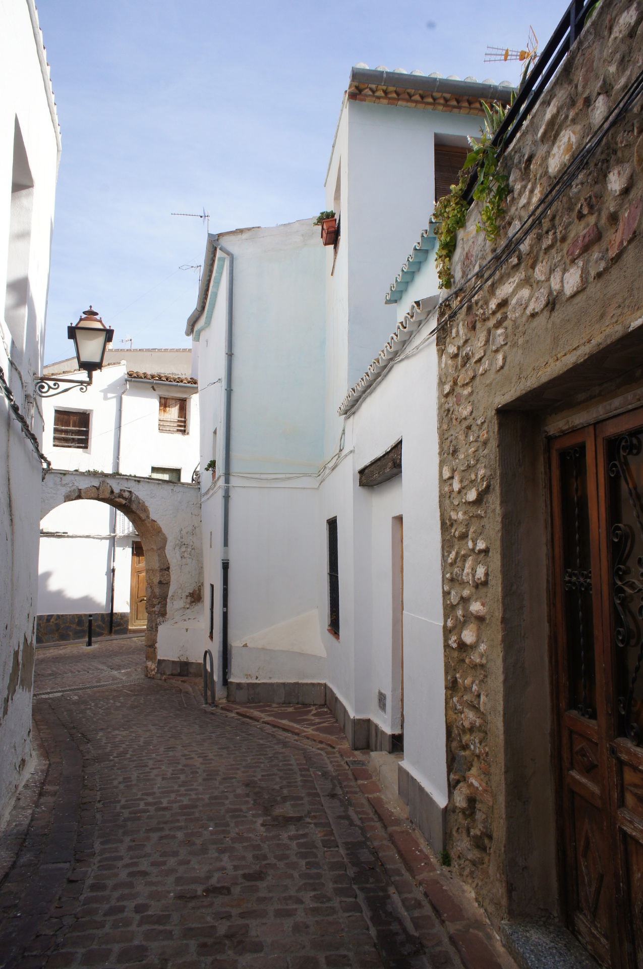 Charming narrow street with stone archway in Valencia's Old Town